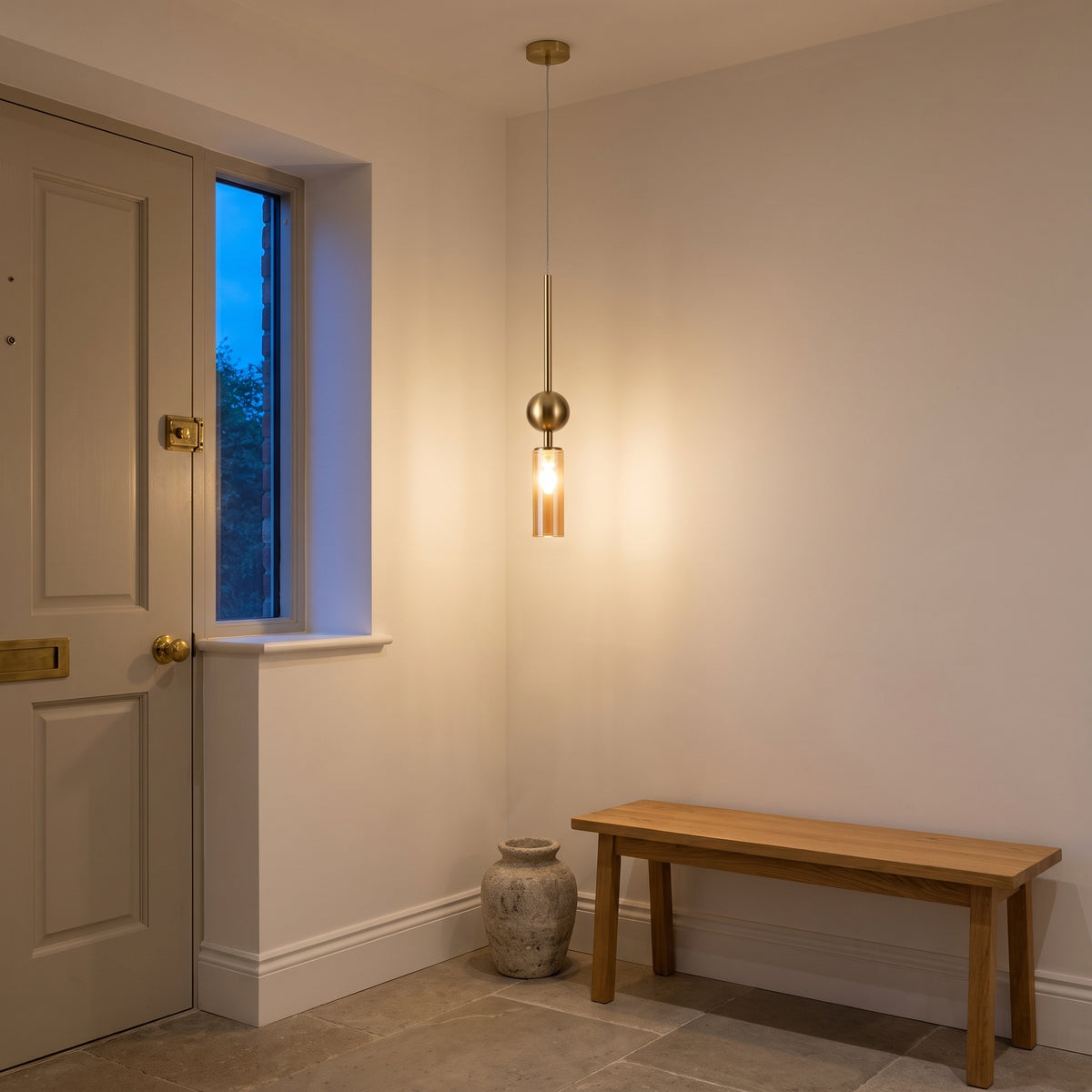 Gold and amber glass tube pendant light in an evening entry hallway