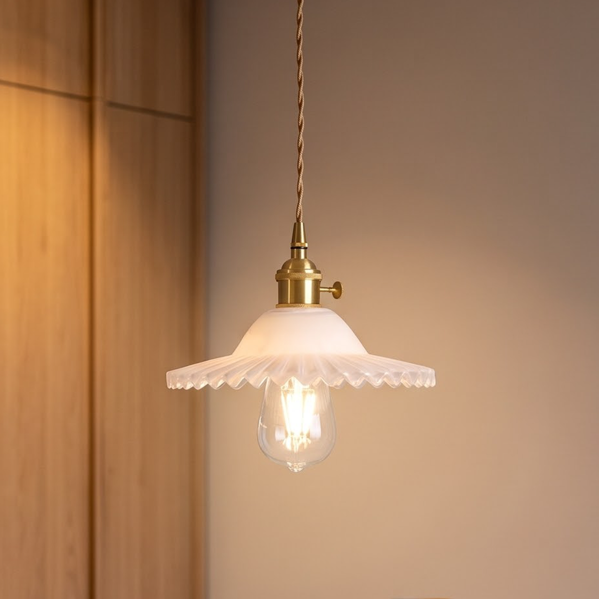 Frosted white scalloped glass pendant over a stone kitchen counter