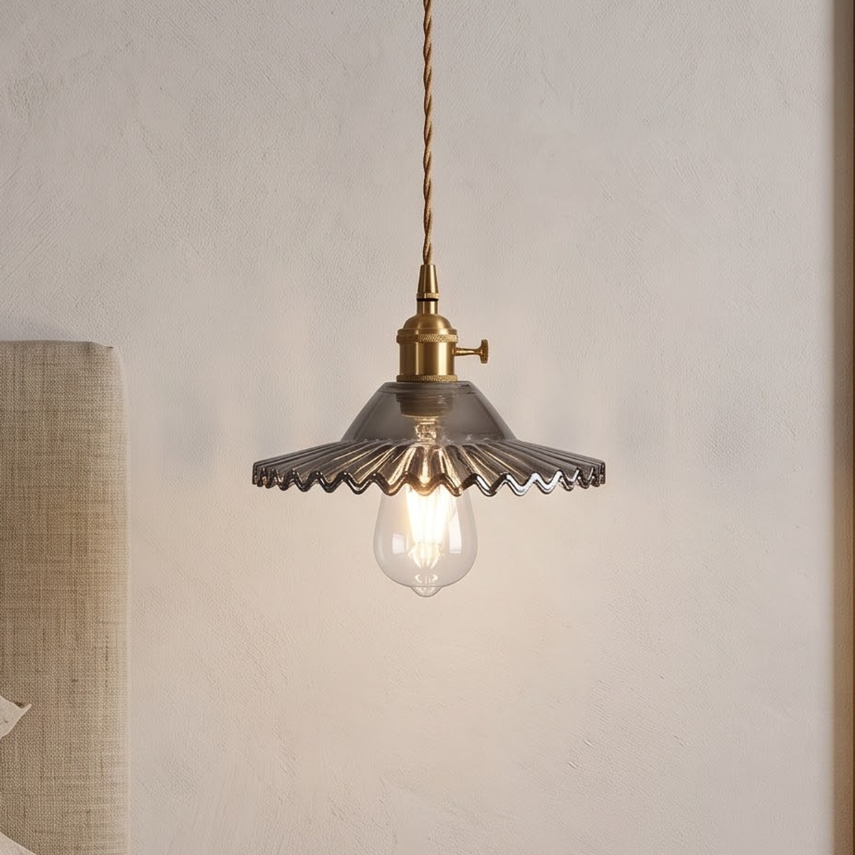 Smoke grey scalloped glass pendant above an oak entry console