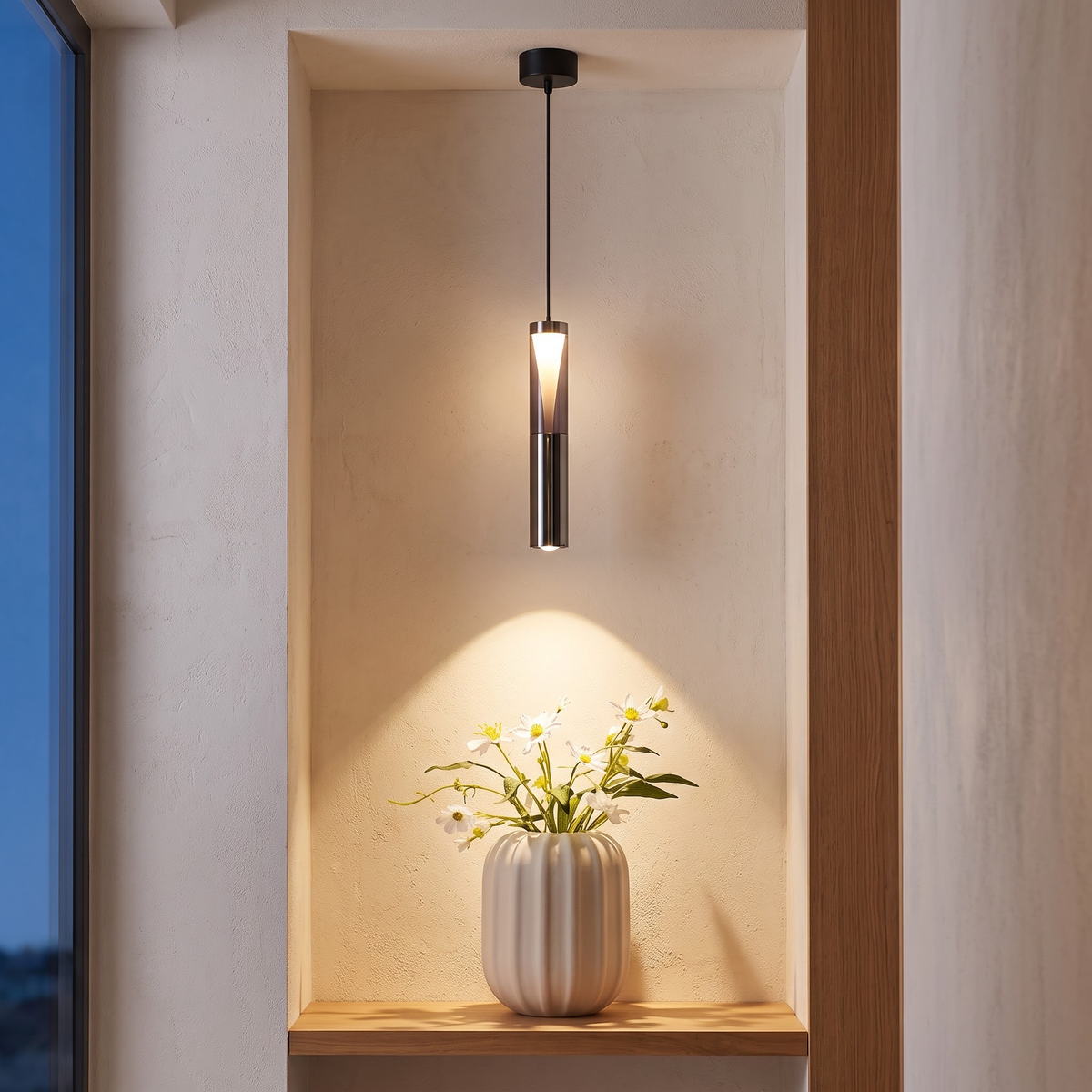 Slim cylinder spotlight pendant lighting a vase on an oak shelf
