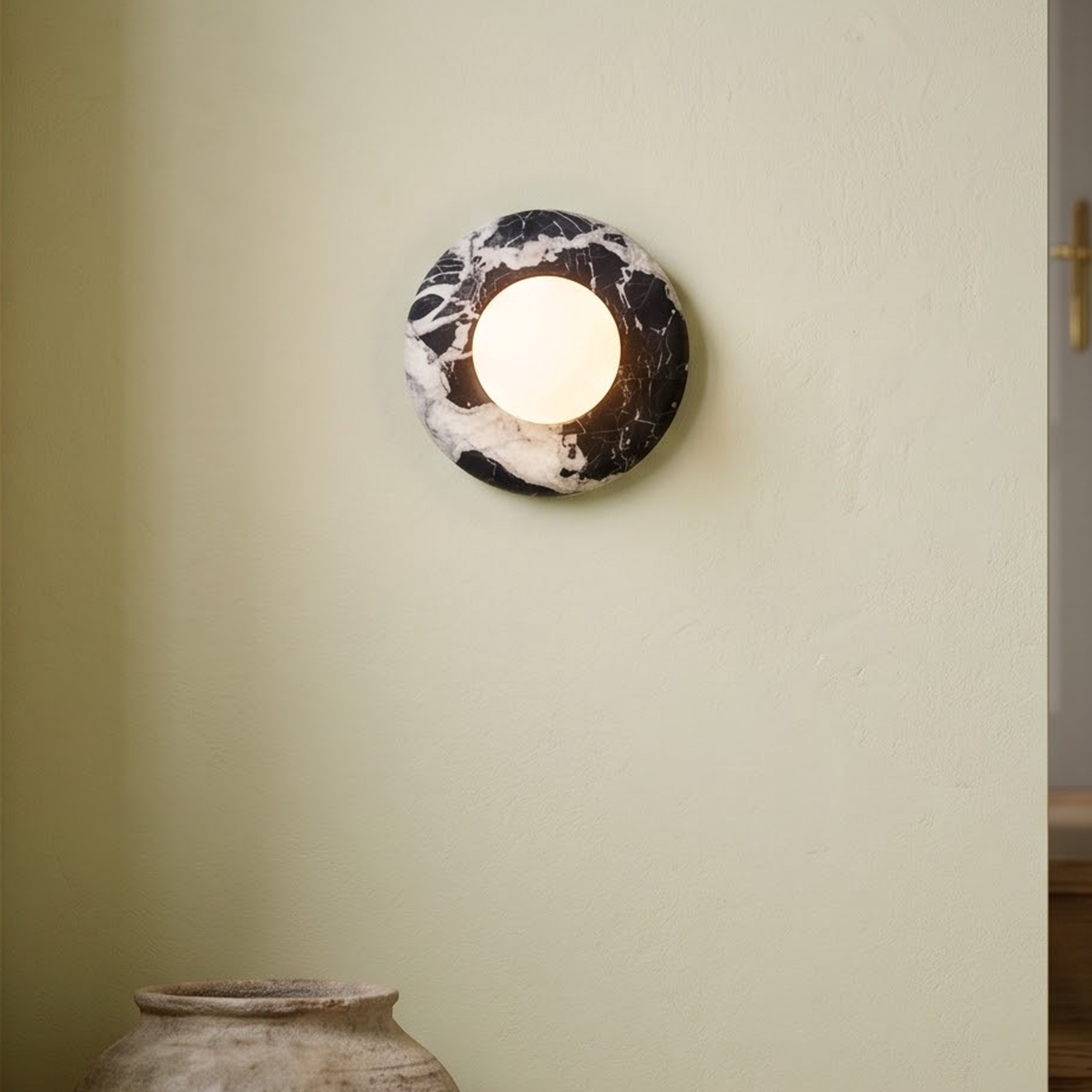 Black marble disc wall light with glass ball on a stair landing