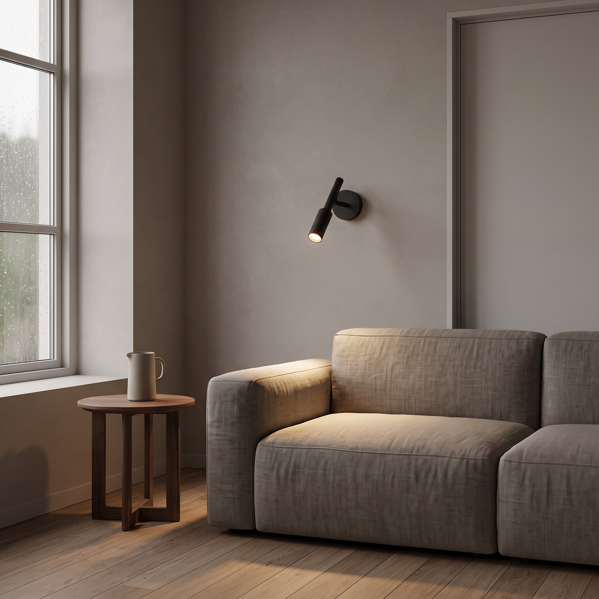 Black adjustable wall spot lighting a linen sofa in a calm living room