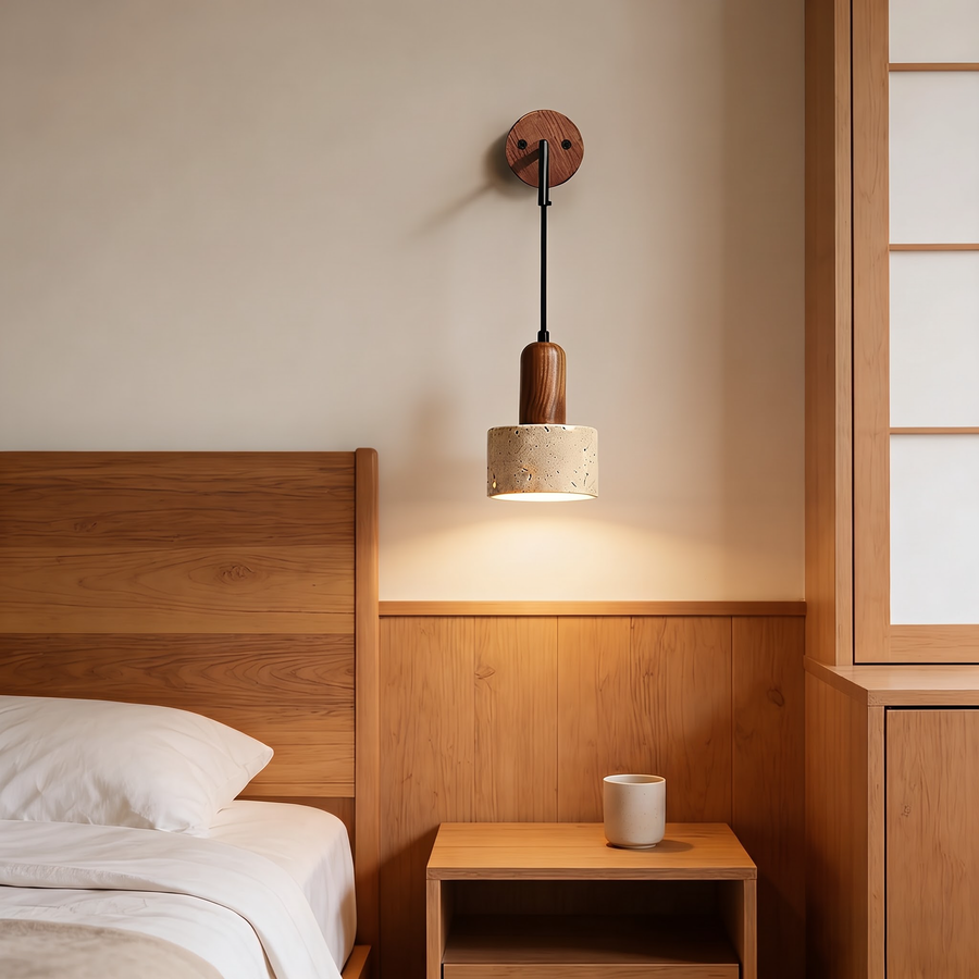 Travertine and walnut wall pendant light glowing above an oak nightstand