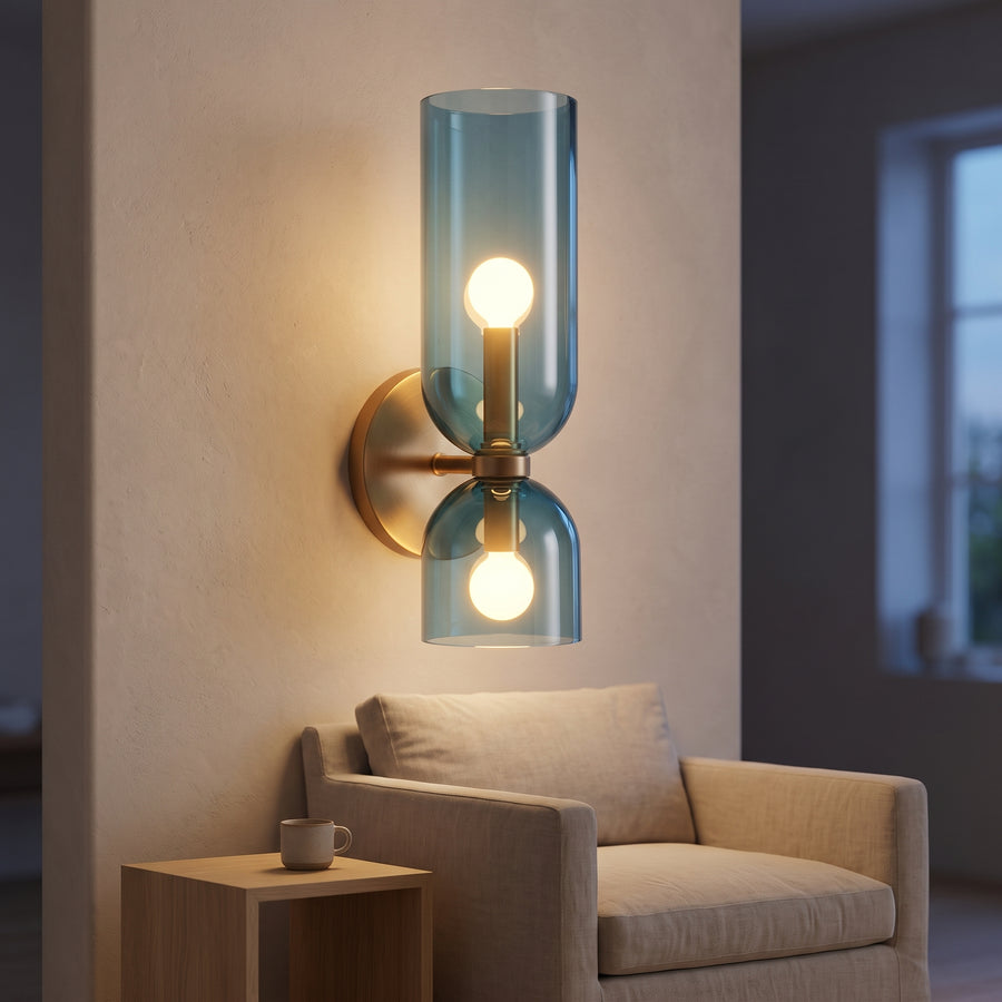 Blue glass up and down wall sconce with brass plate glowing at dusk