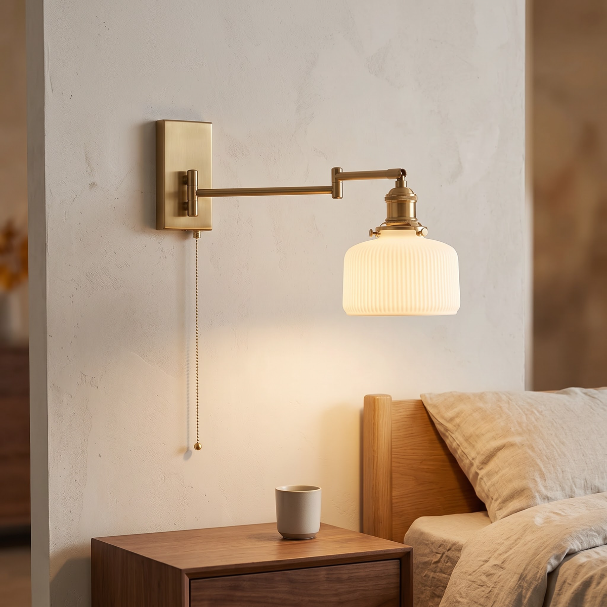 Brass swing-arm wall sconce with ribbed ceramic shade and pull chain