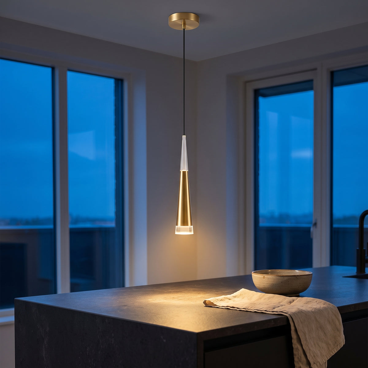 Gold cone mini pendant light over a dark stone kitchen island