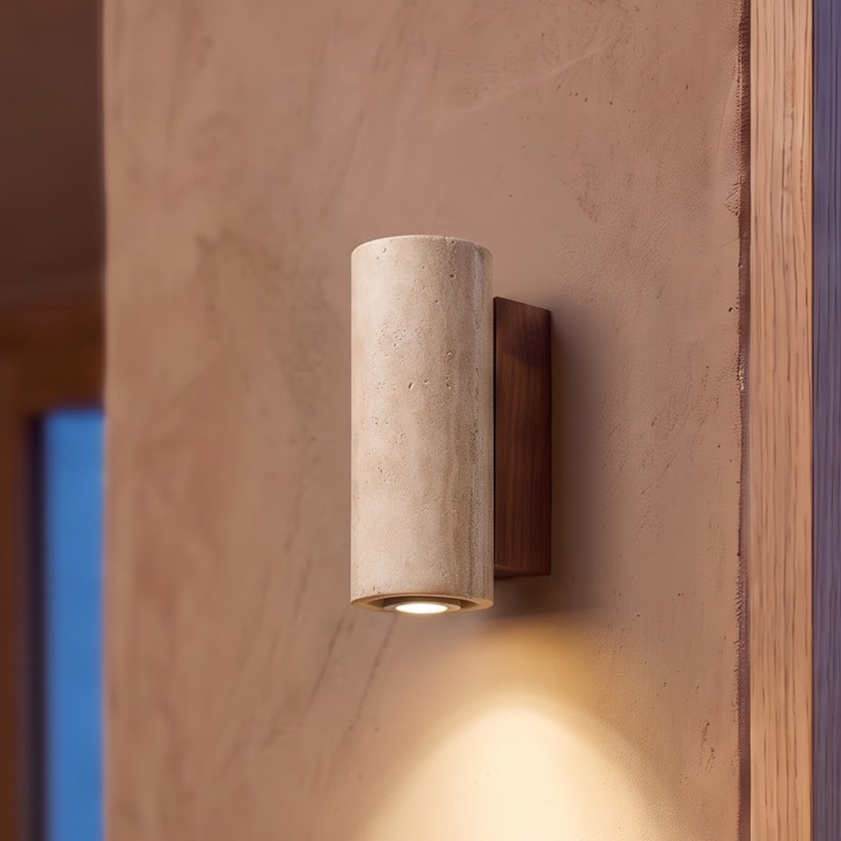 Round travertine stone wall sconce with walnut base glowing at dusk