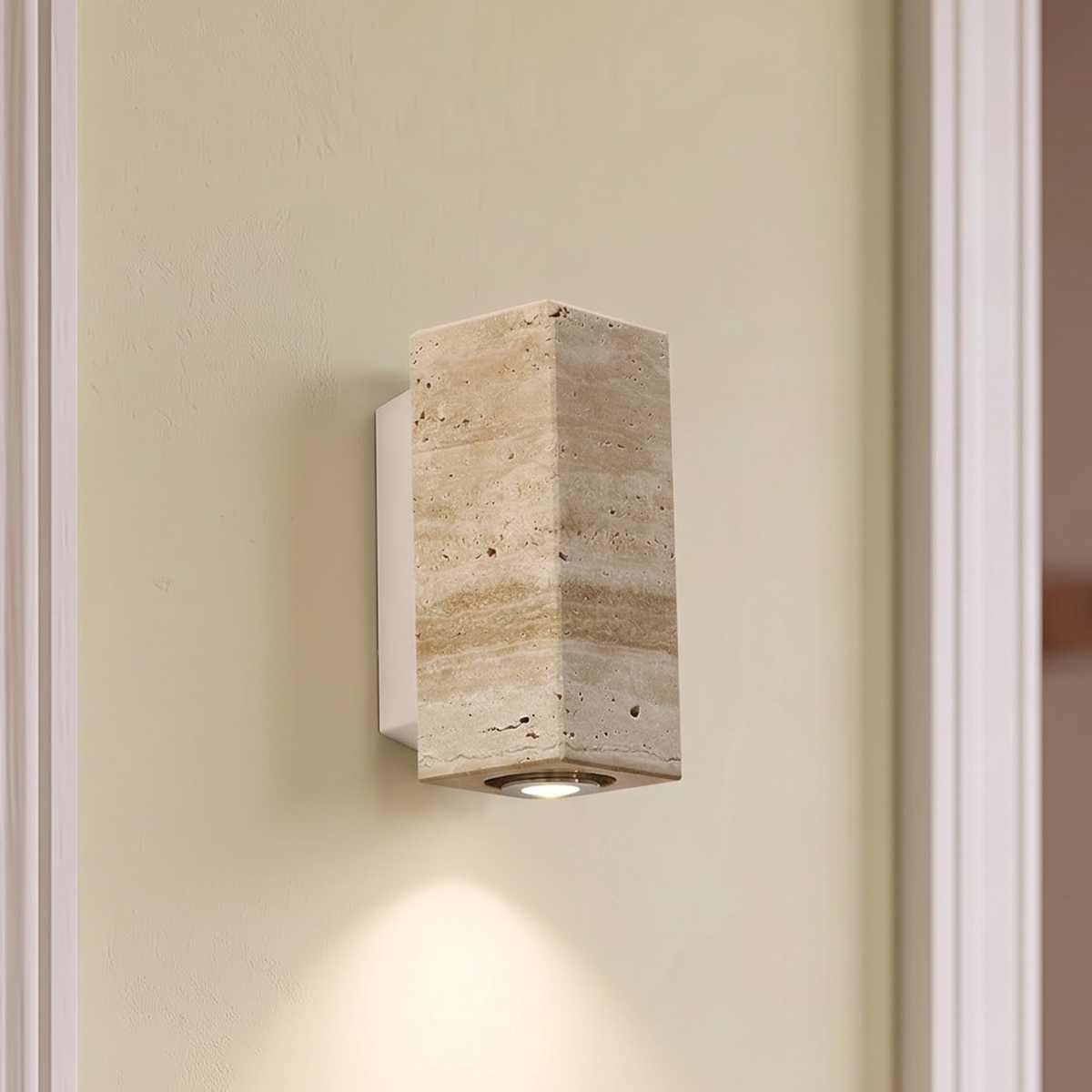 Square travertine wall sconce on a white metal plate in an entry