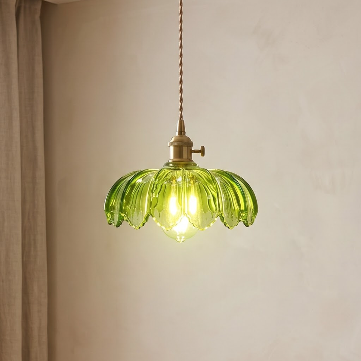 Green glass lotus pendant light glowing above an oak dining table