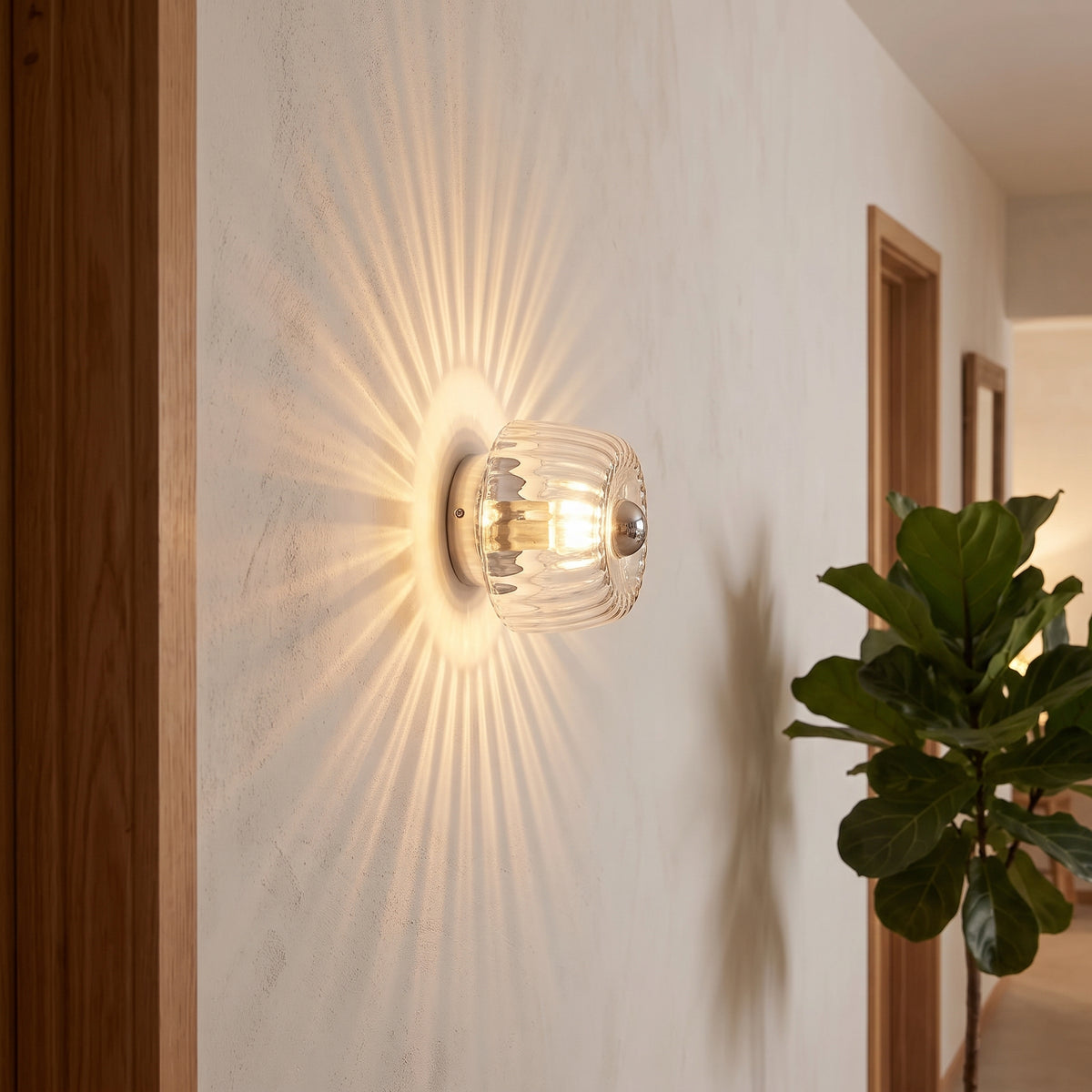 Clear fluted glass wall light casting sunburst rays in an evening hallway