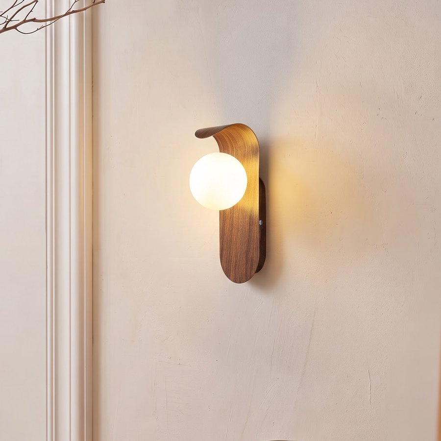 Walnut wood-grain wall light with frosted globe beside a bedroom door