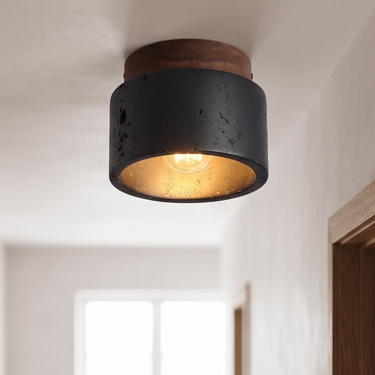 Black cave stone flush ceiling light glowing in a Japandi hallway