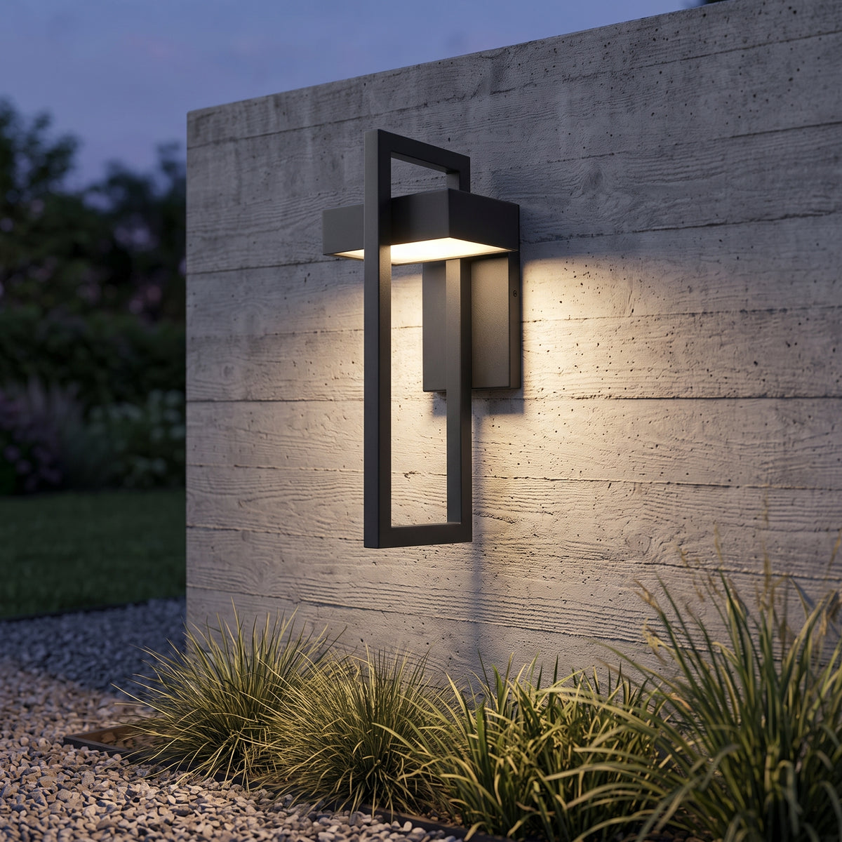 Black outdoor wall lantern on a concrete garden wall at dusk