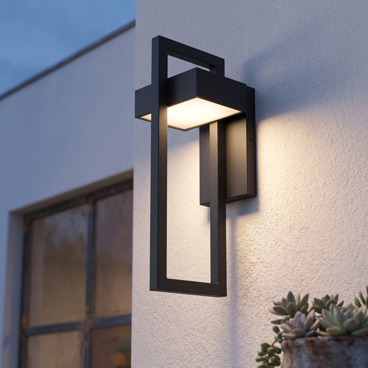 Close view of black rectangular outdoor wall light lit at dusk