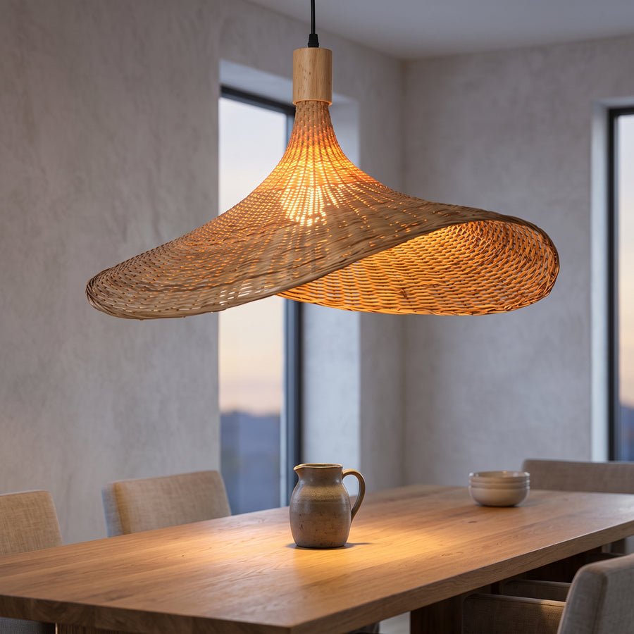 Wide bamboo hat pendant over an oak dining table at dusk