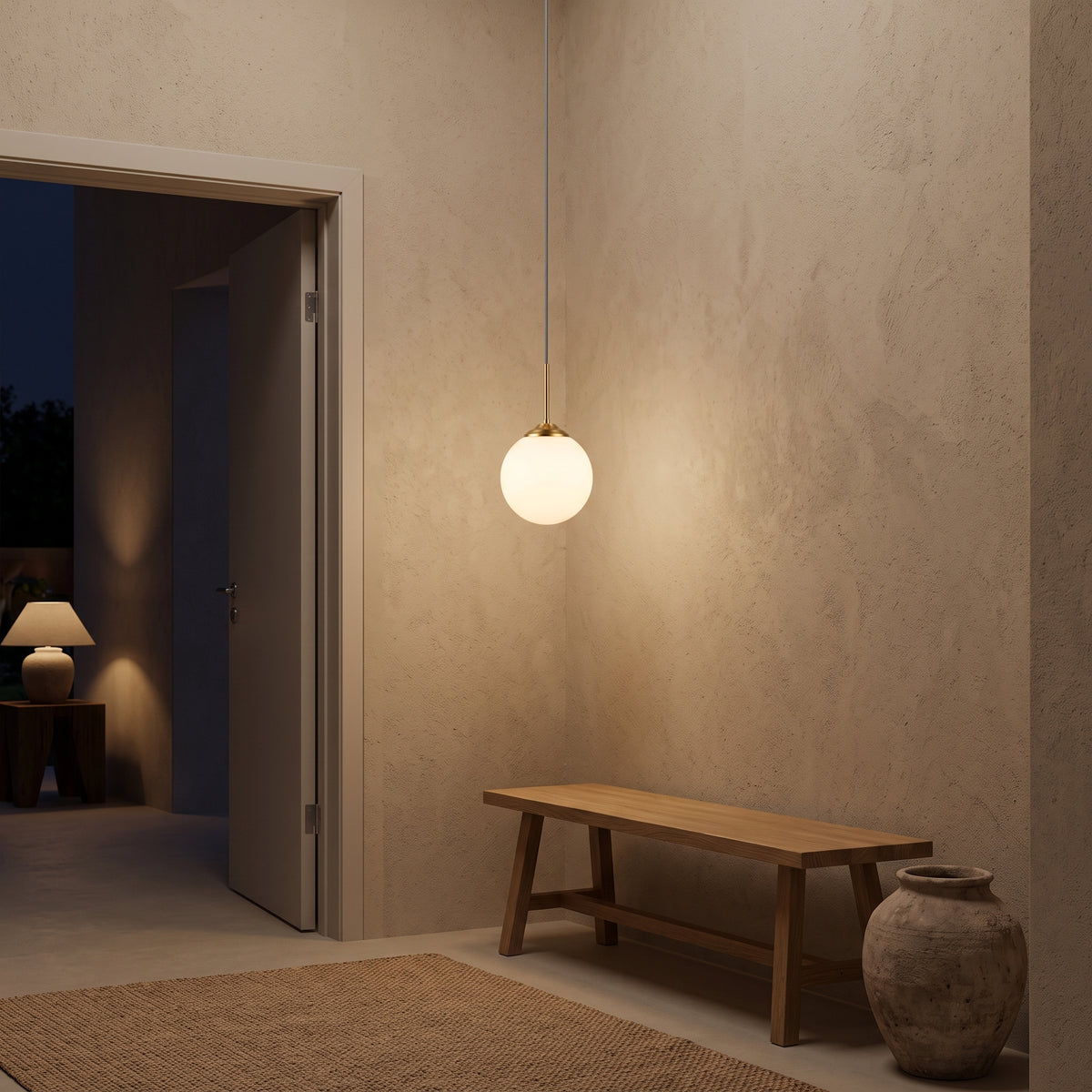 Milk white glass globe pendant in a calm plaster hallway at night