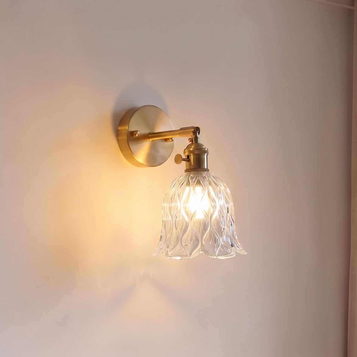 Clear ribbed glass bell wall sconce with brass arm over a console