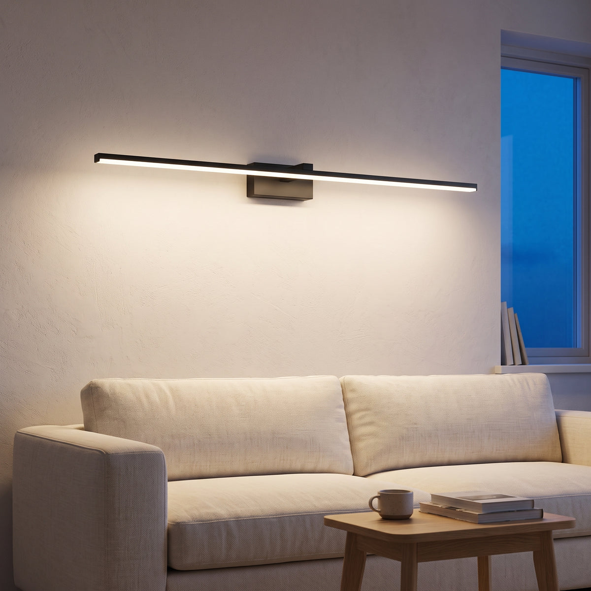 Black linear wall sconce above a linen sofa at dusk