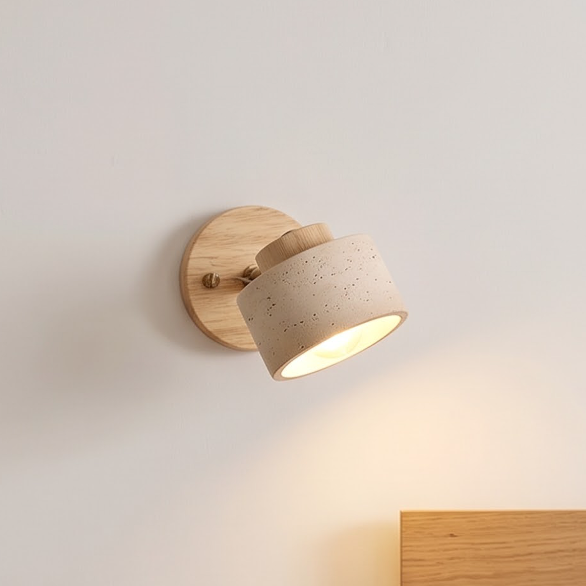 Light wood and stone swivel wall sconce glowing beside a doorway