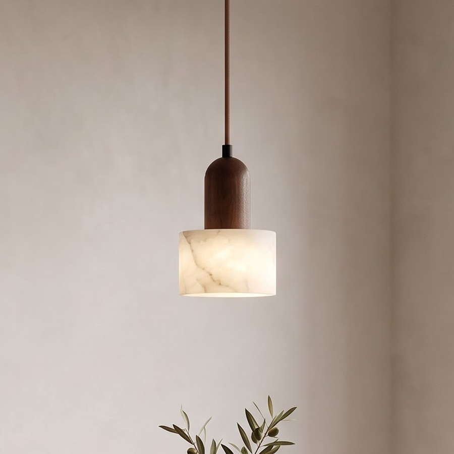 White marble pendant with walnut cap glowing above an oak dining table