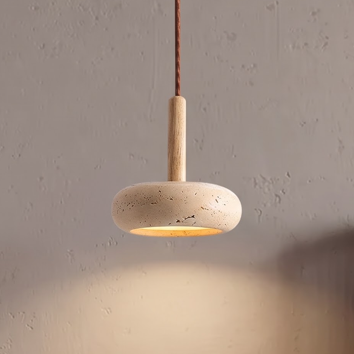 Travertine-look stone pendant glowing warm above a walnut nightstand
