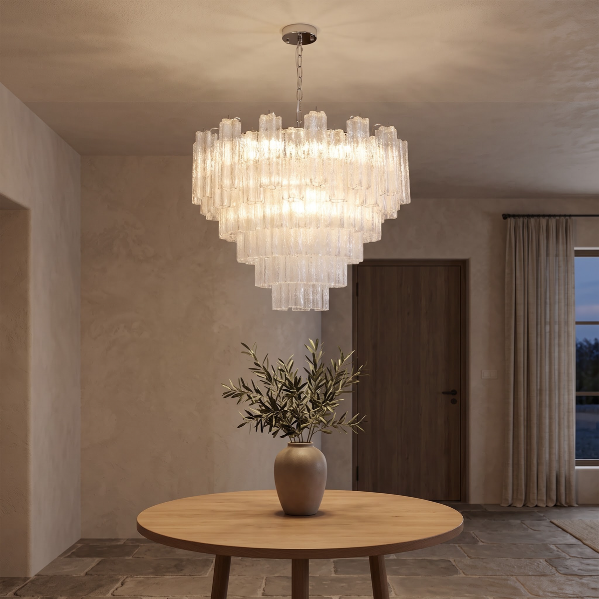 Large tiered glass chandelier lighting a high-ceilinged plaster entry hall