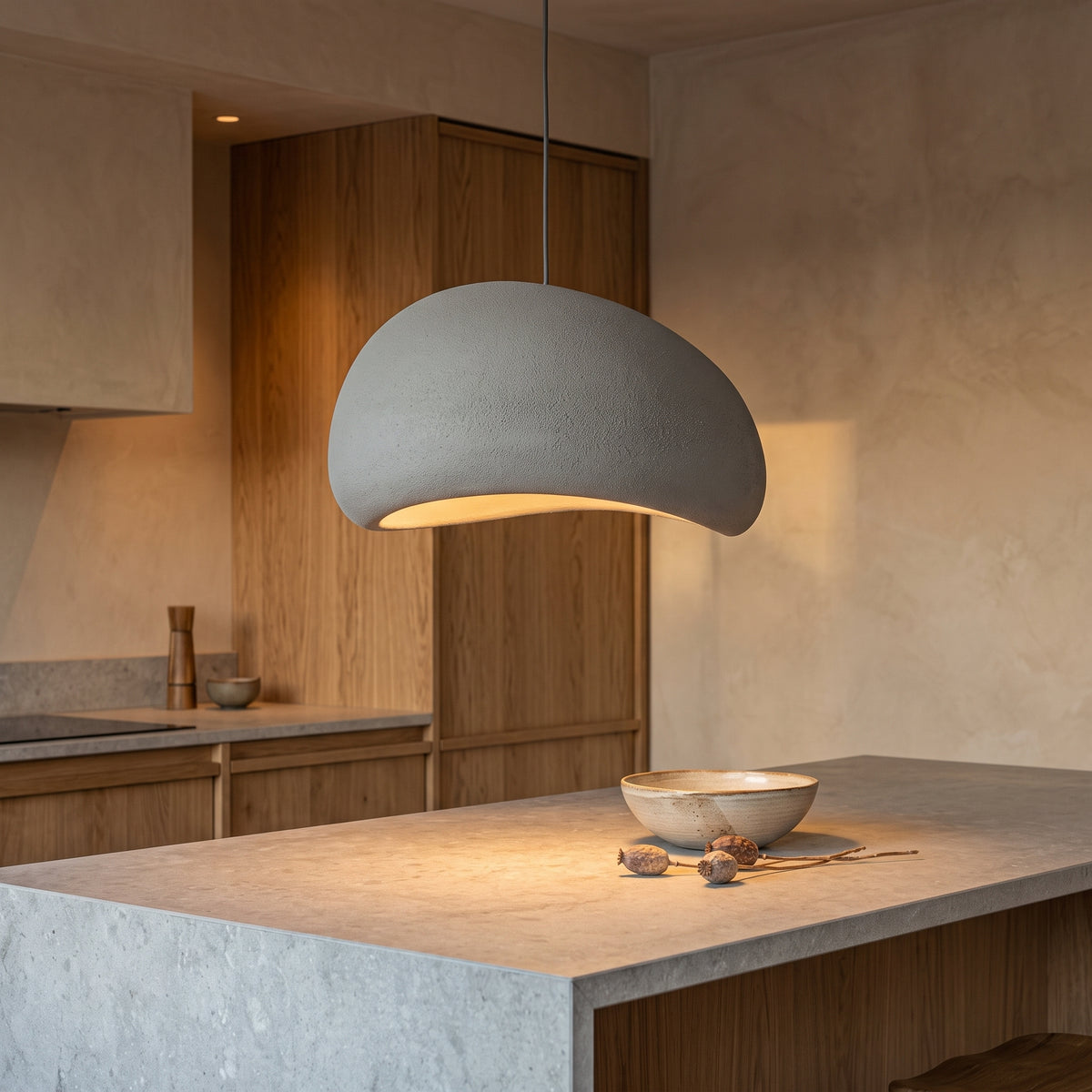Gray smooth dome pendant light over a stone kitchen island