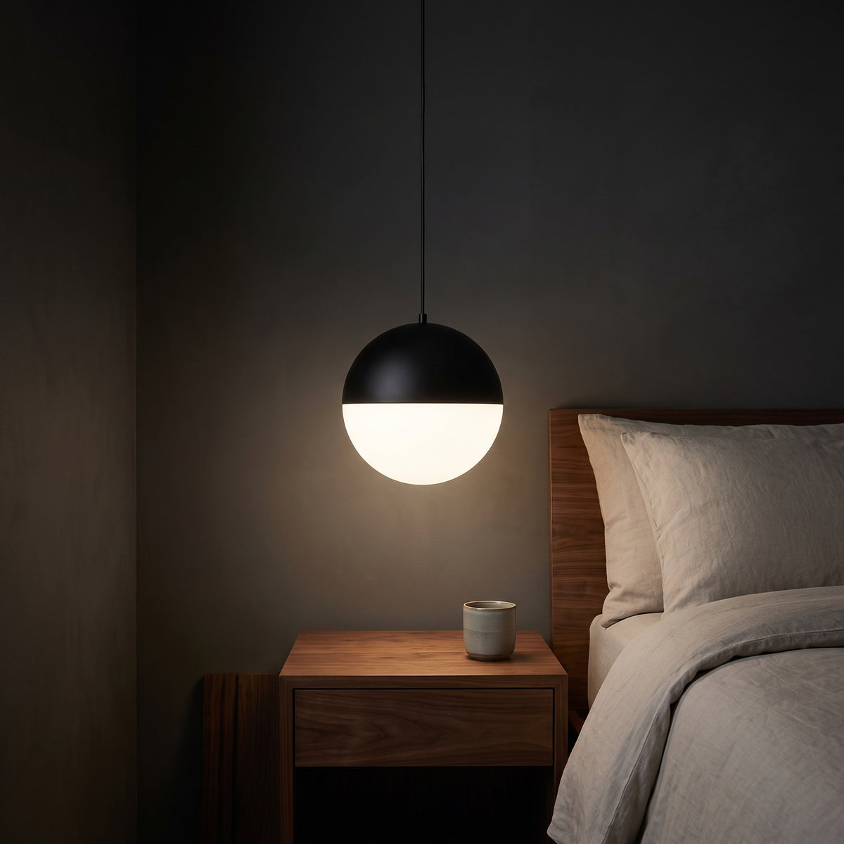 Black and opal glass pendant as bedside light in a calm bedroom