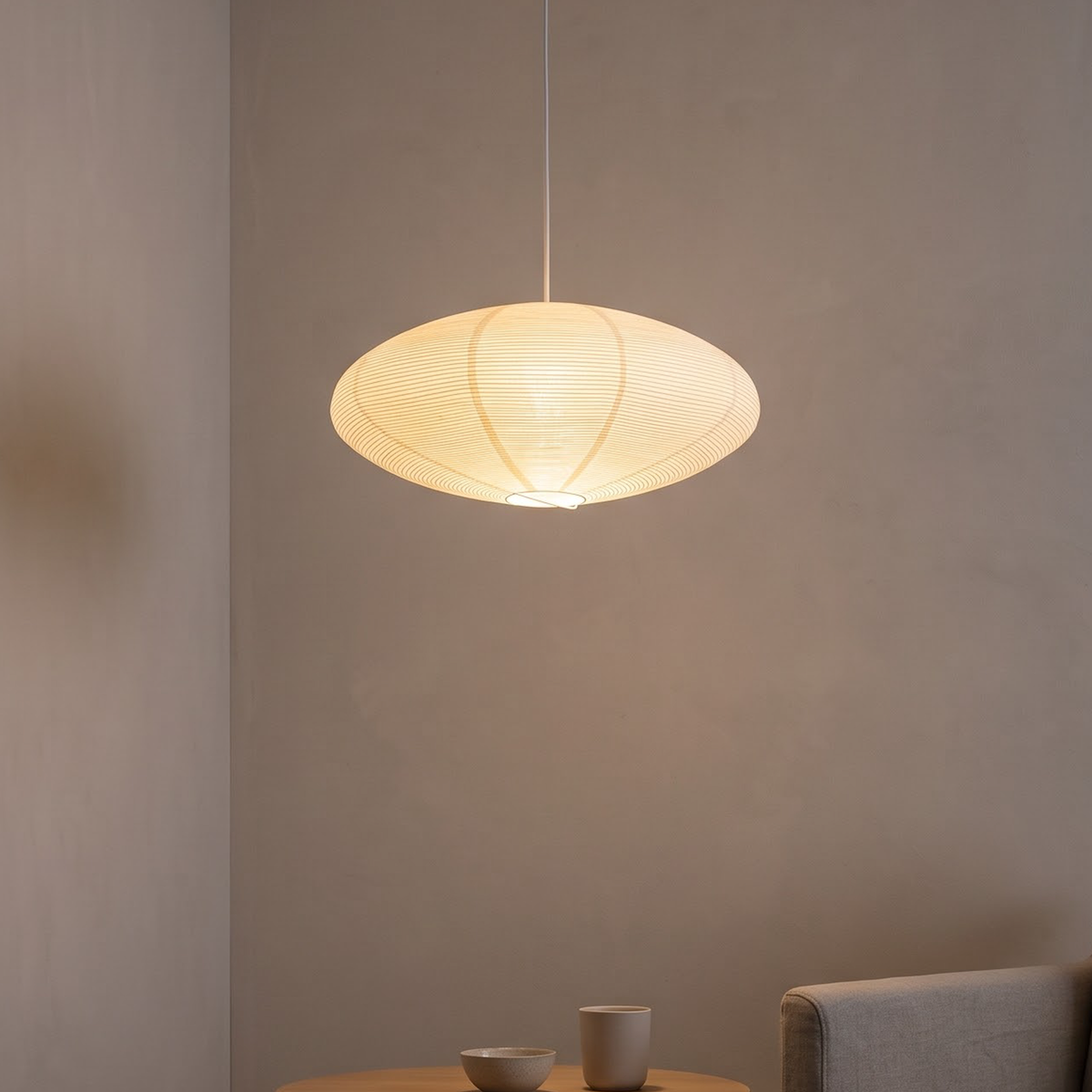 Ribbed paper lantern pendant glowing over an oak dining table