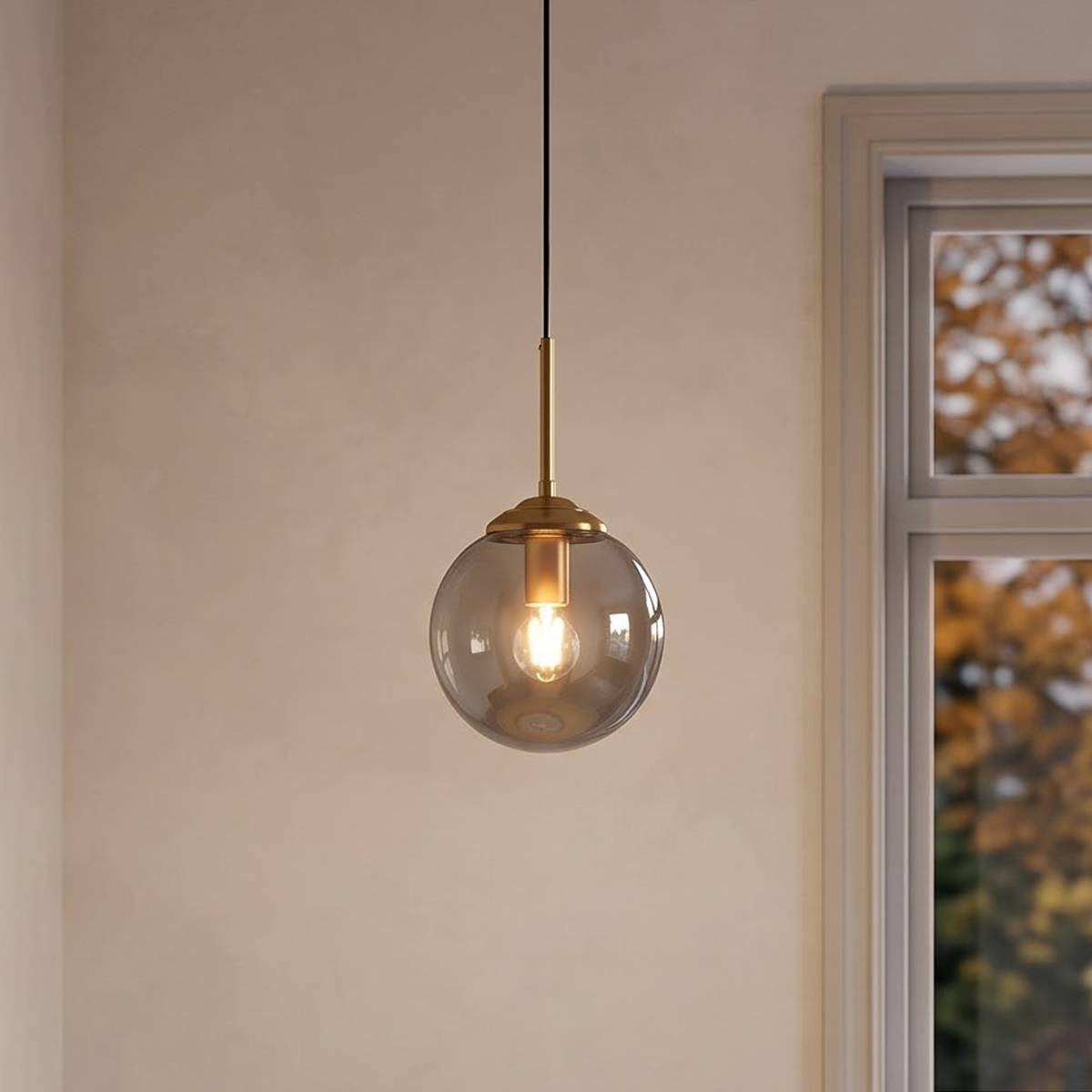 Smoke gray glass globe pendant over a round oak table