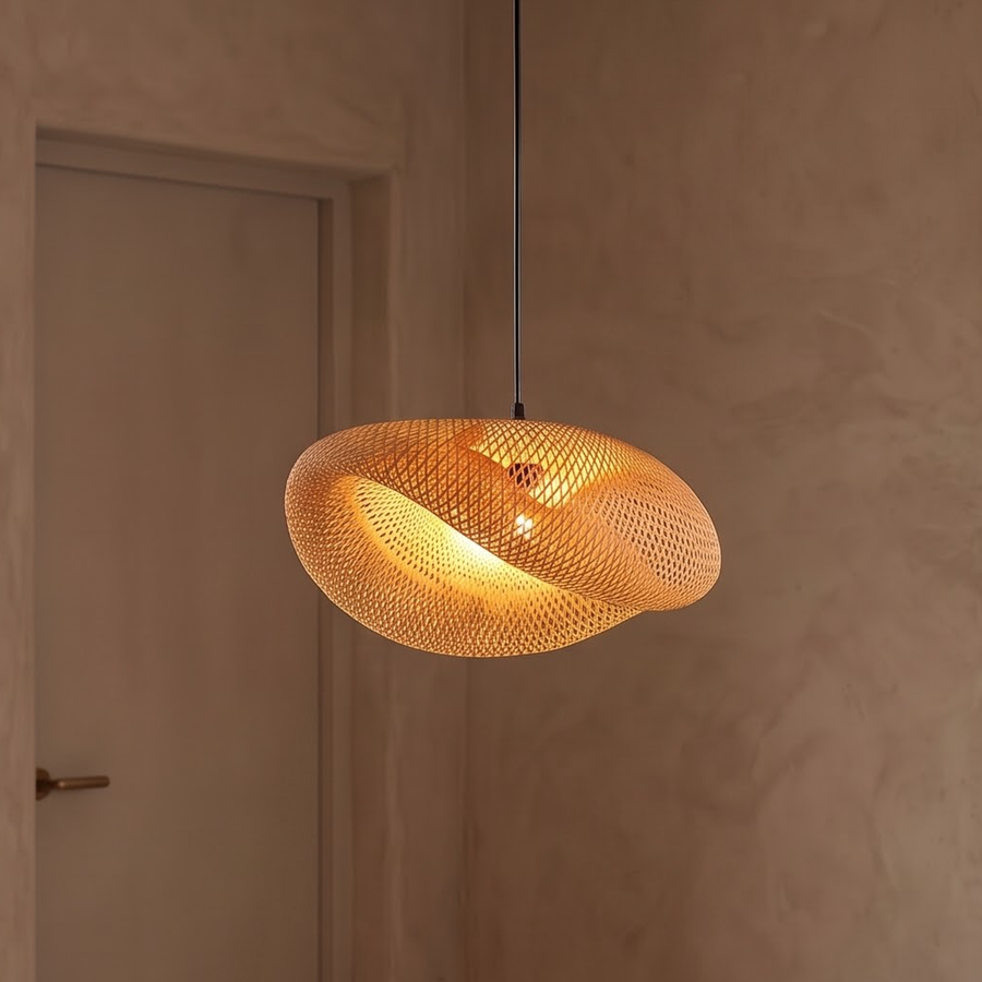 Twisted woven bamboo wave pendant with black cord over a dining table