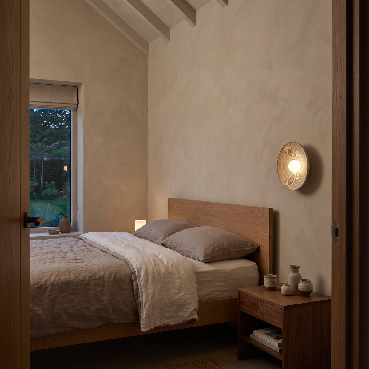 Wood-tone ribbed disc wall light glowing in a wabi-sabi living room