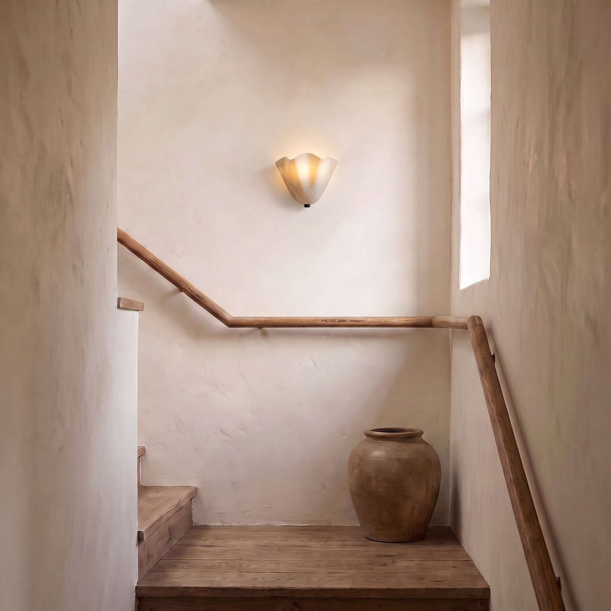 Cream glass flower wall light on a lime plaster stair landing