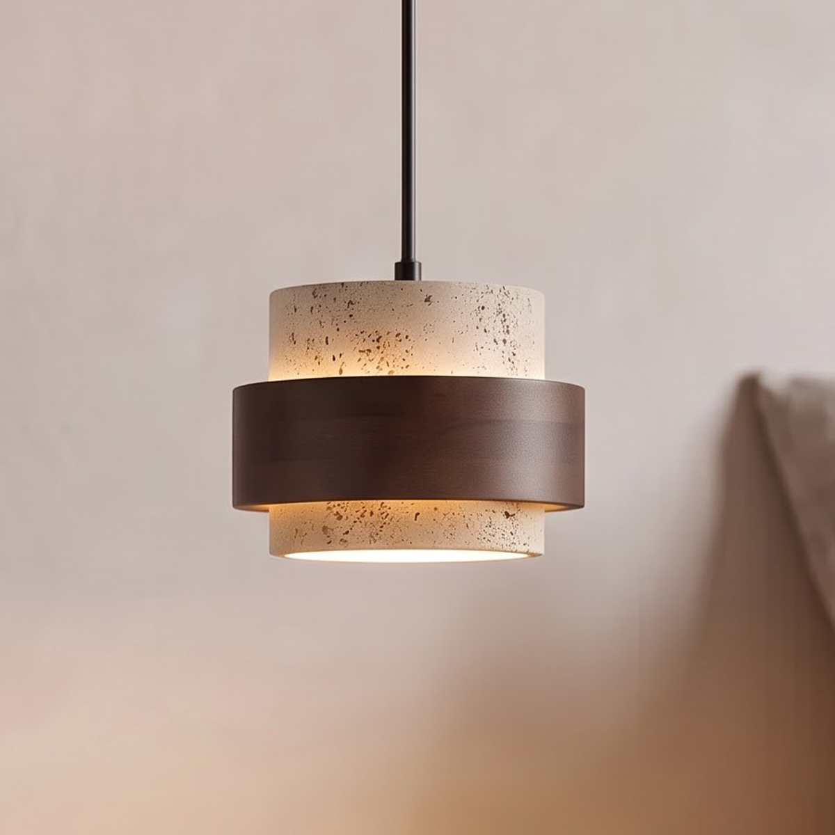 Travertine and walnut pendant light glowing above a bedside nightstand