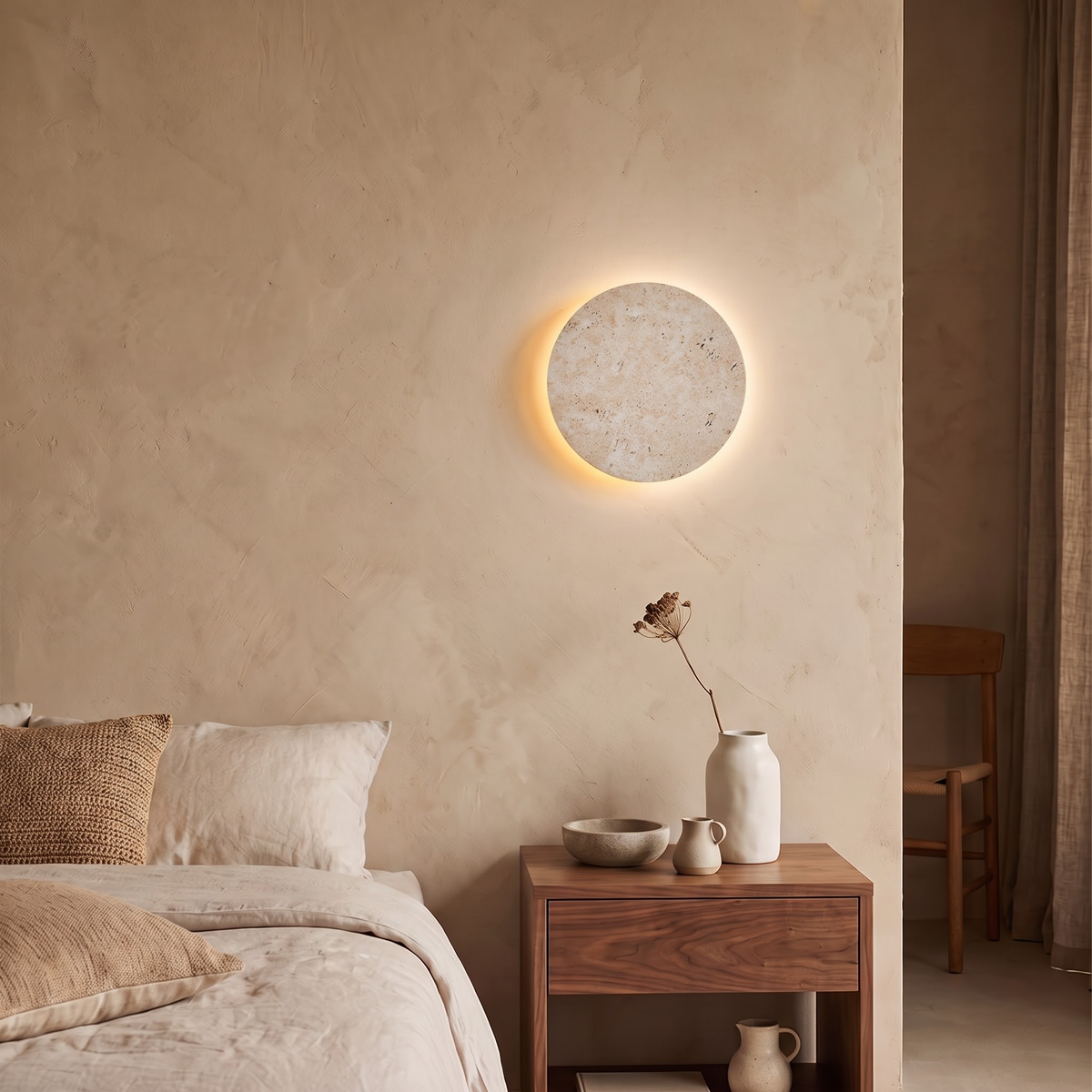 Round stone wall light above a walnut nightstand in evening light