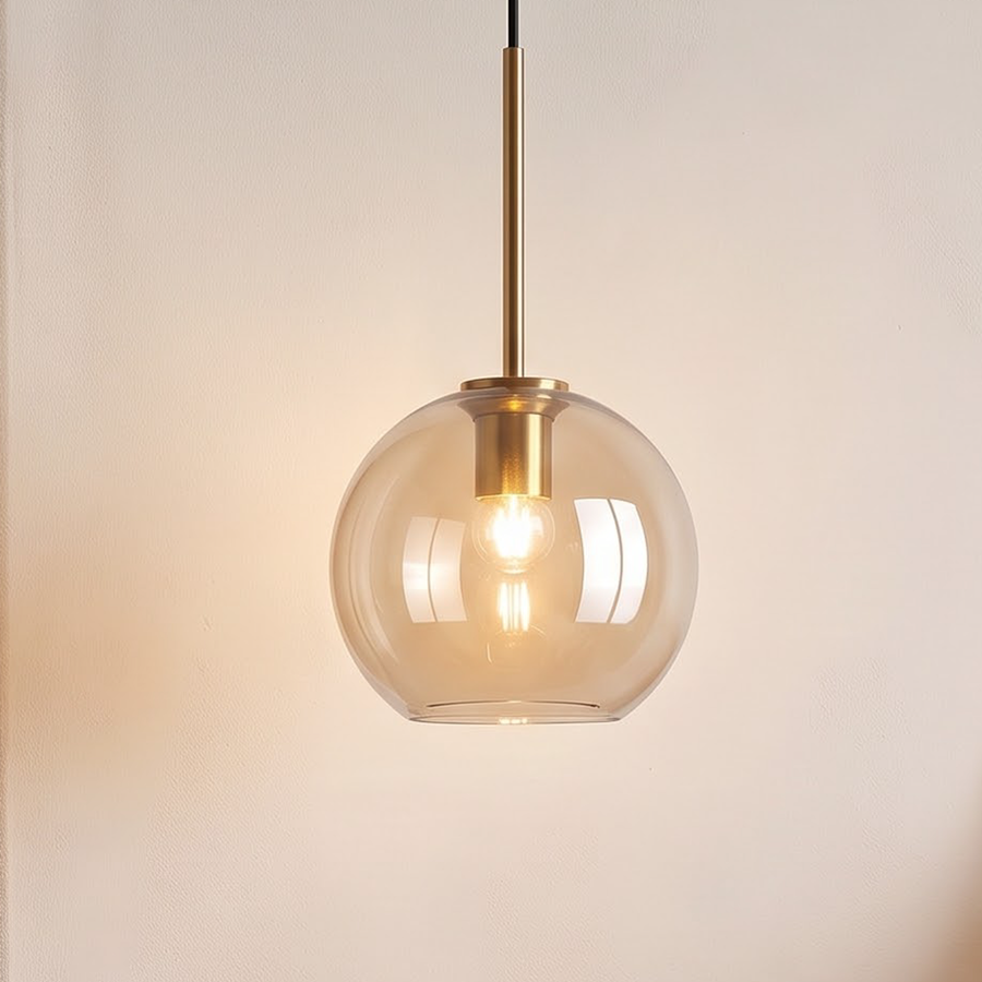 Small amber glass globe pendant with brass stem above a nightstand