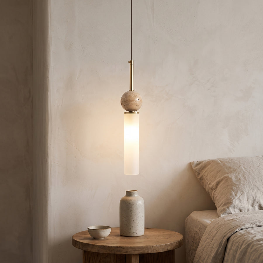 Travertine ball and frosted glass tube pendant above an oak bedside table