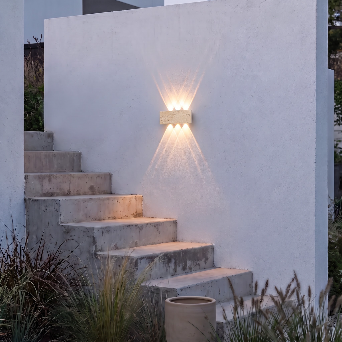 Travertine block wall light beside outdoor concrete garden steps