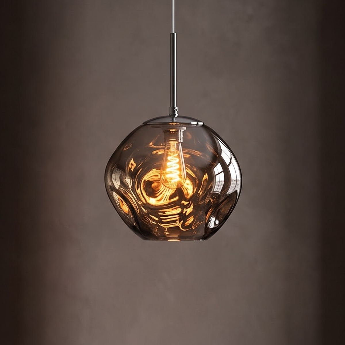 Smoke grey molten glass pendant light glowing over a dark oak table