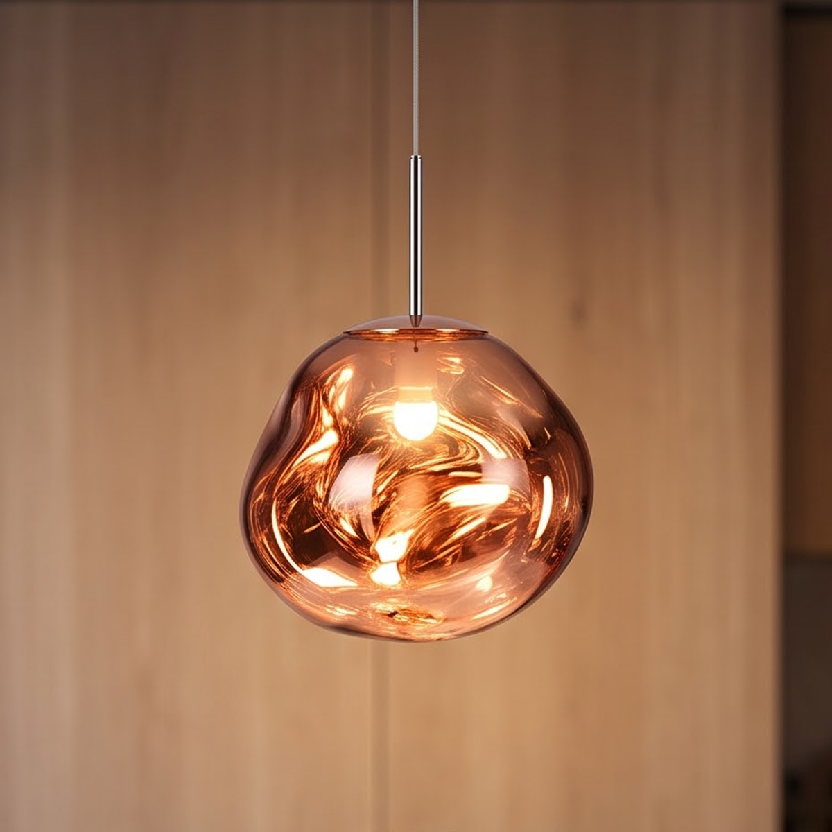 Rose gold molten glass pendant light over a stone kitchen counter