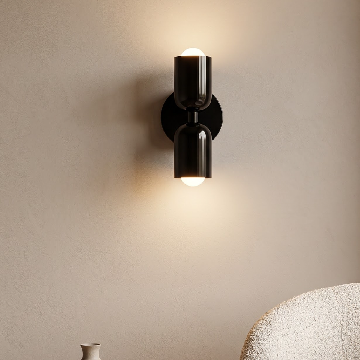 Gloss black up and down wall sconce above an oak side table