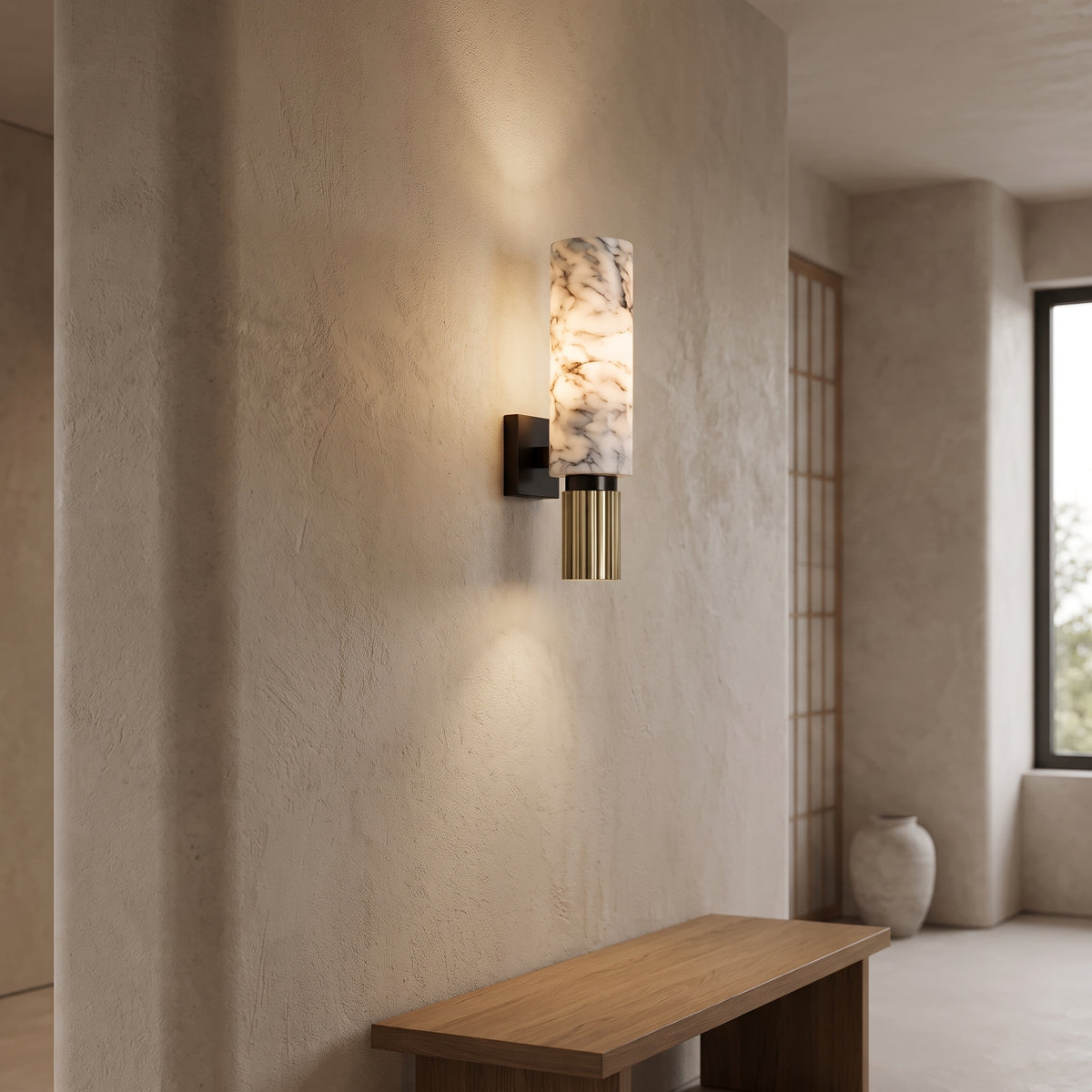 Marble cylinder sconce glowing above an oak bench in a plaster hallway