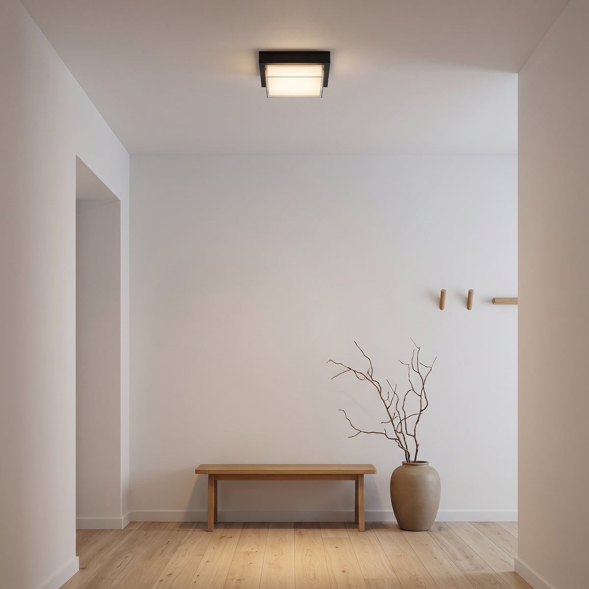 Black square flush-mount ceiling light glowing in a Japandi entry hall