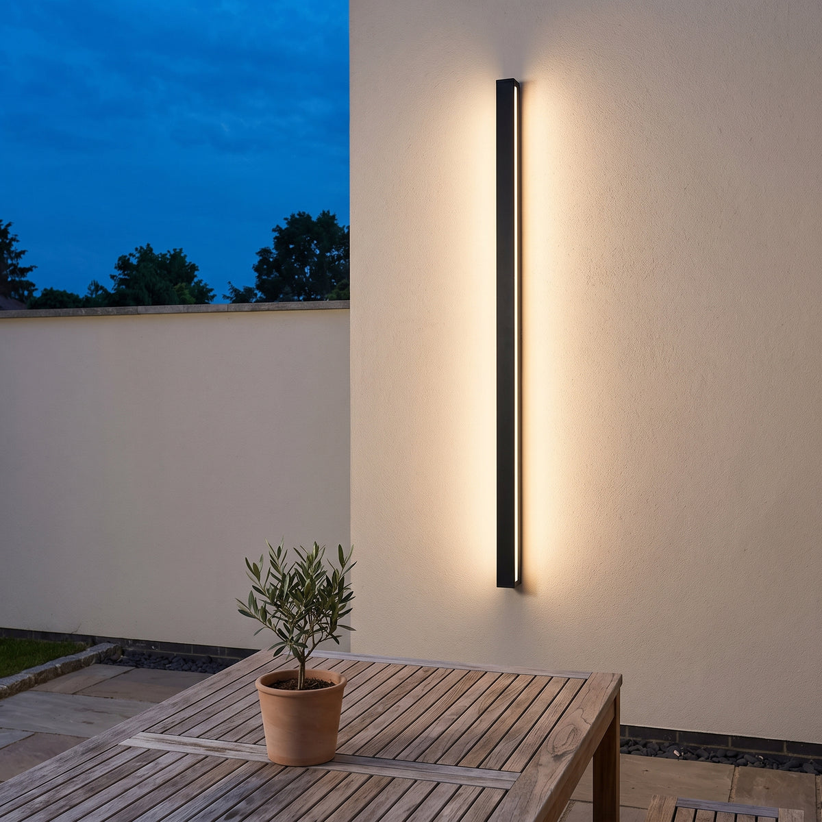 Vertical black outdoor linear wall light above a terrace dining table