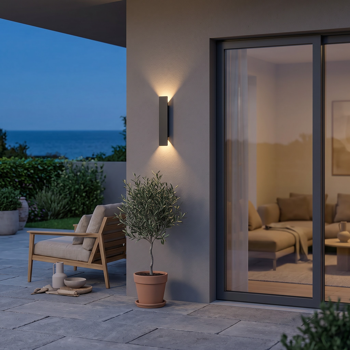 Slim black outdoor wall light beside a glass patio door at dusk