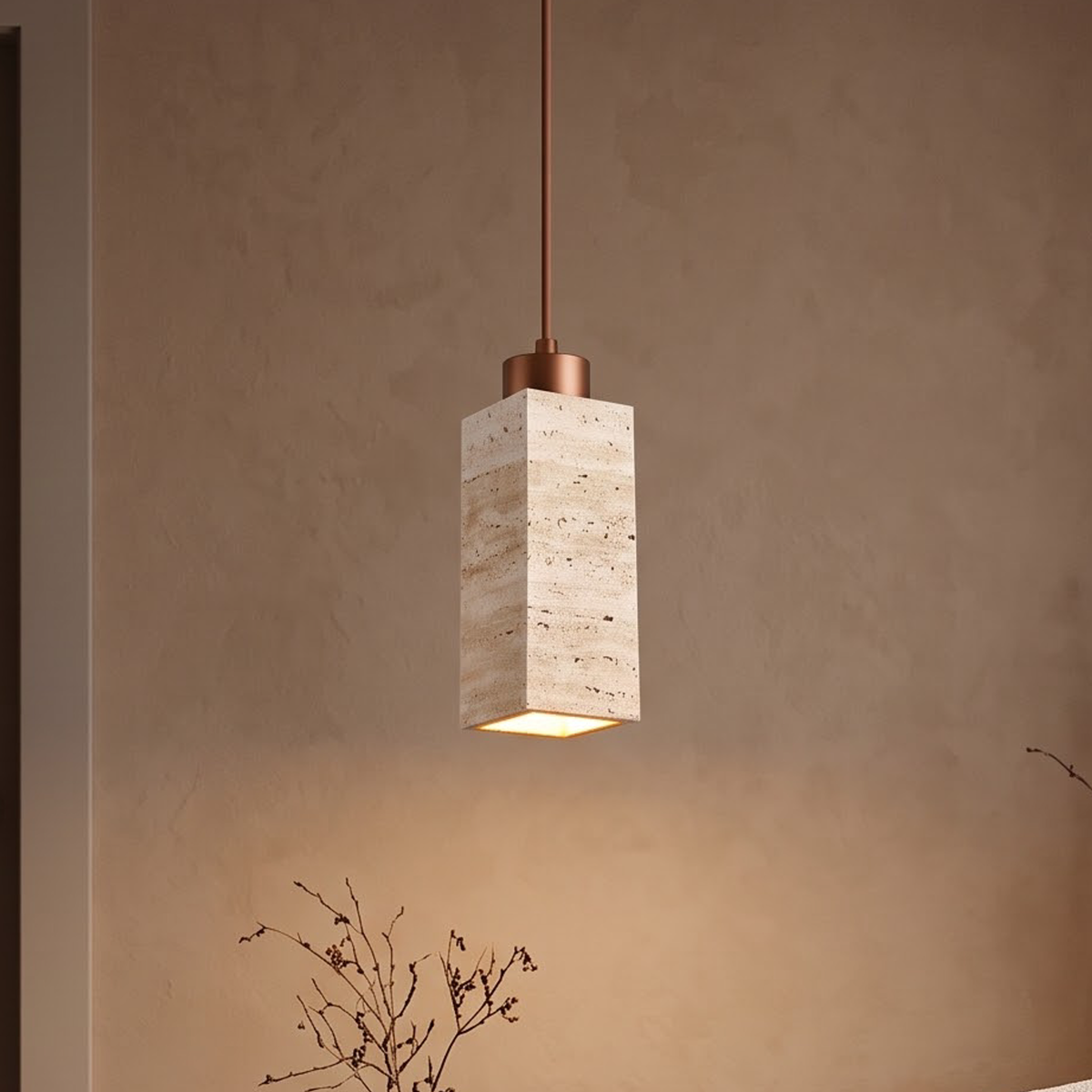 Square travertine pendant light glowing above a walnut side table