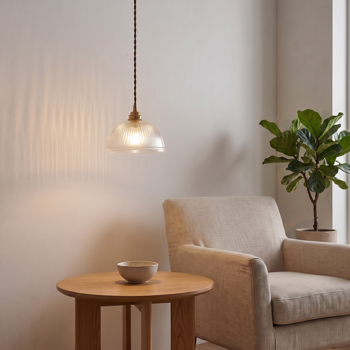 Fluted glass dome pendant hanging over a reading chair and side table