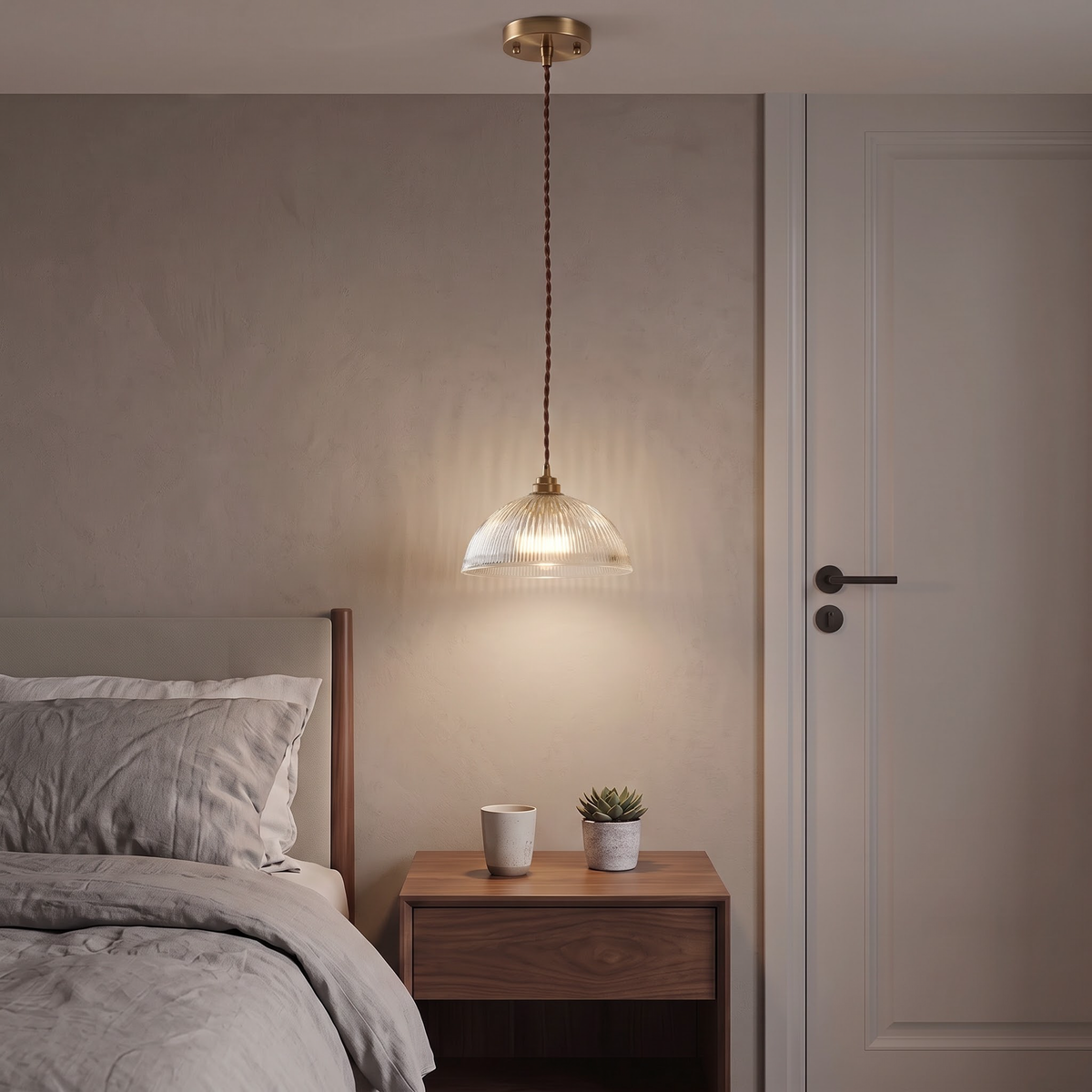 Ribbed glass bedside pendant glowing above a walnut nightstand