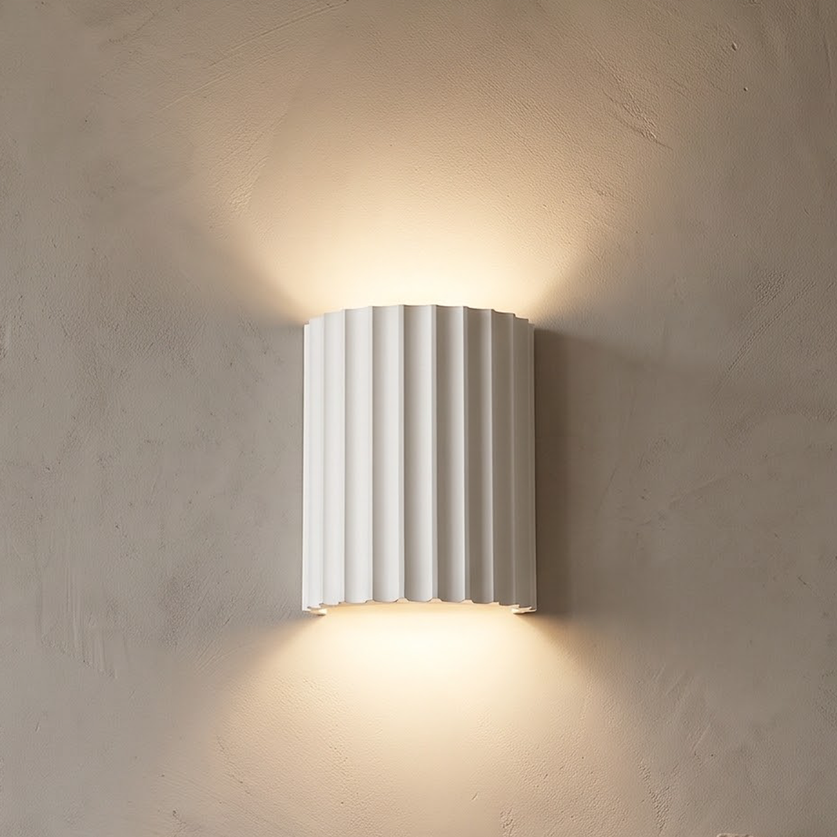 White fluted wall sconce glowing beside an oak door frame at dusk