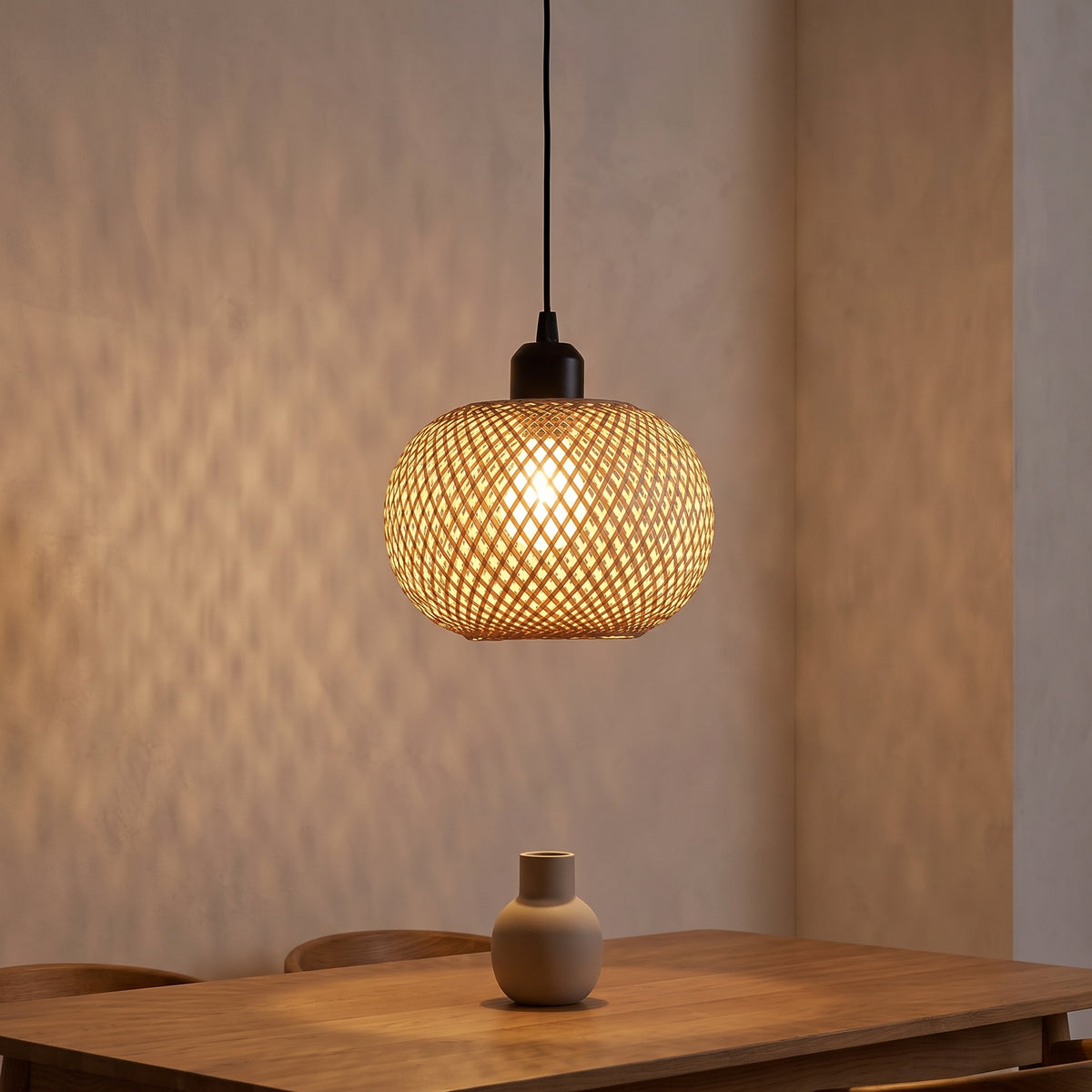 Bamboo globe pendant glowing over an oak dining table at dusk